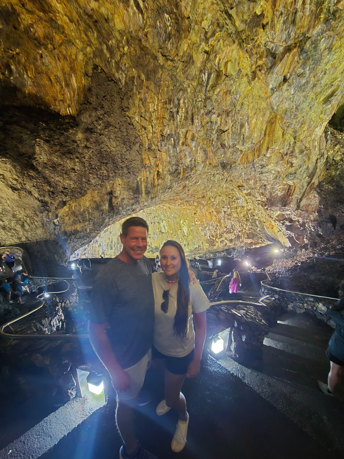 Nikki and Q inside a golden-lit volcanic cave.