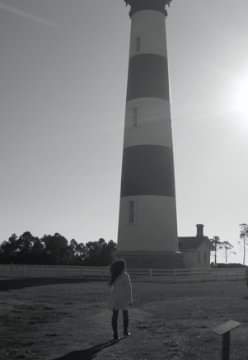 Nikki beneath the striped Bodie Island Lighthouse, in black and white.
