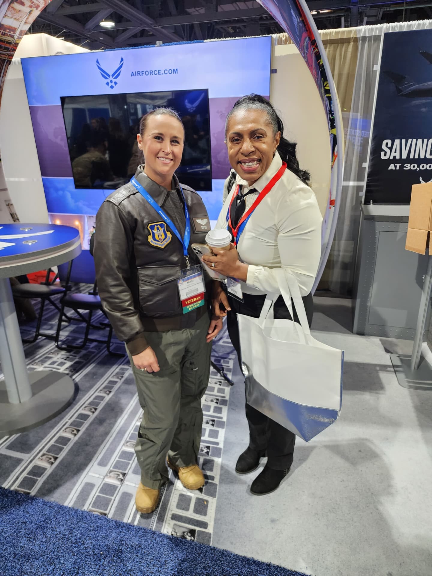 Nikki in her leather jacket with a woman at an Air Force recruiting booth.