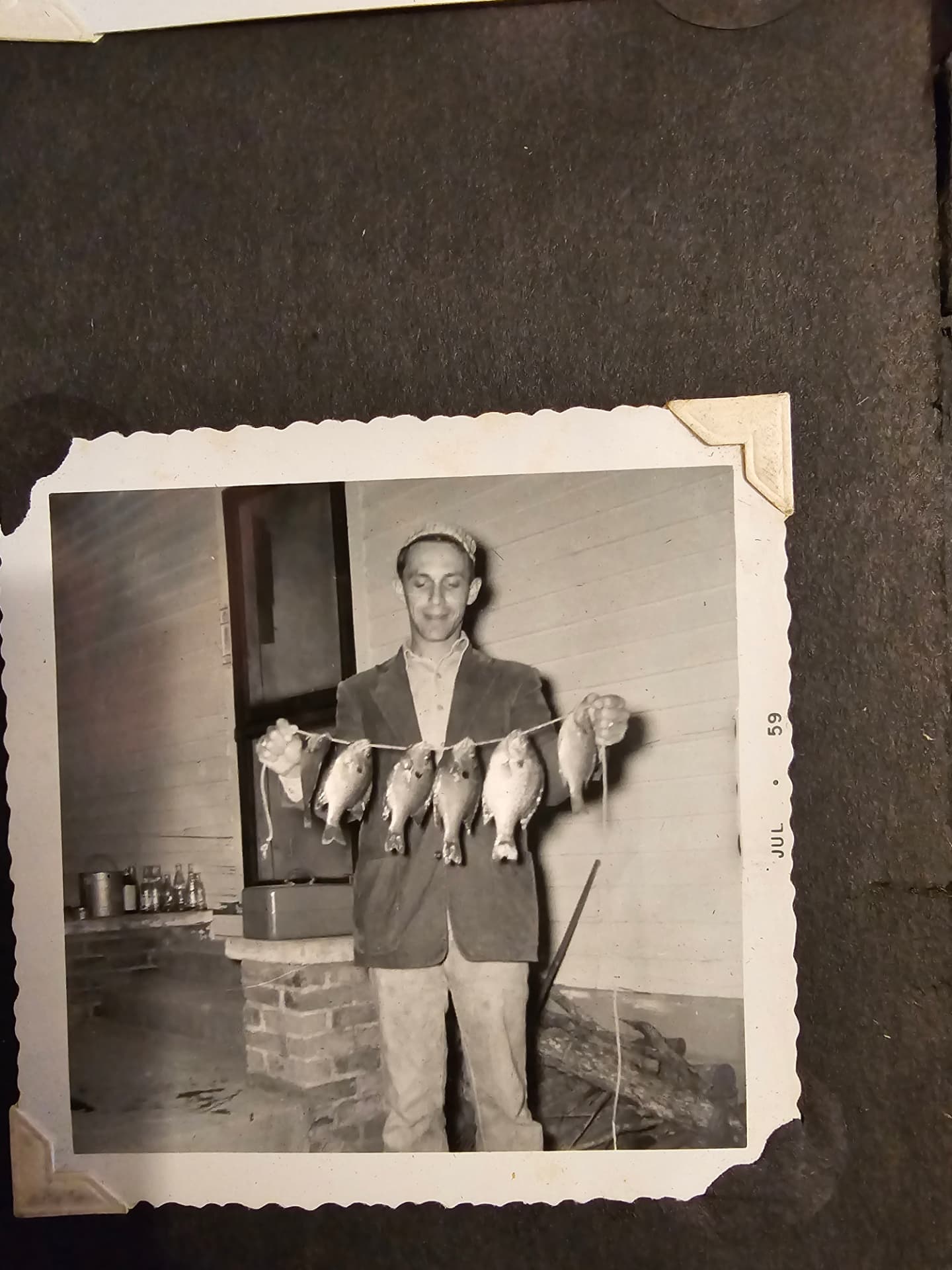 A black-and-white snapshot dated July 1959 of Granddaddy Fred smiling and holding up a string of bream.