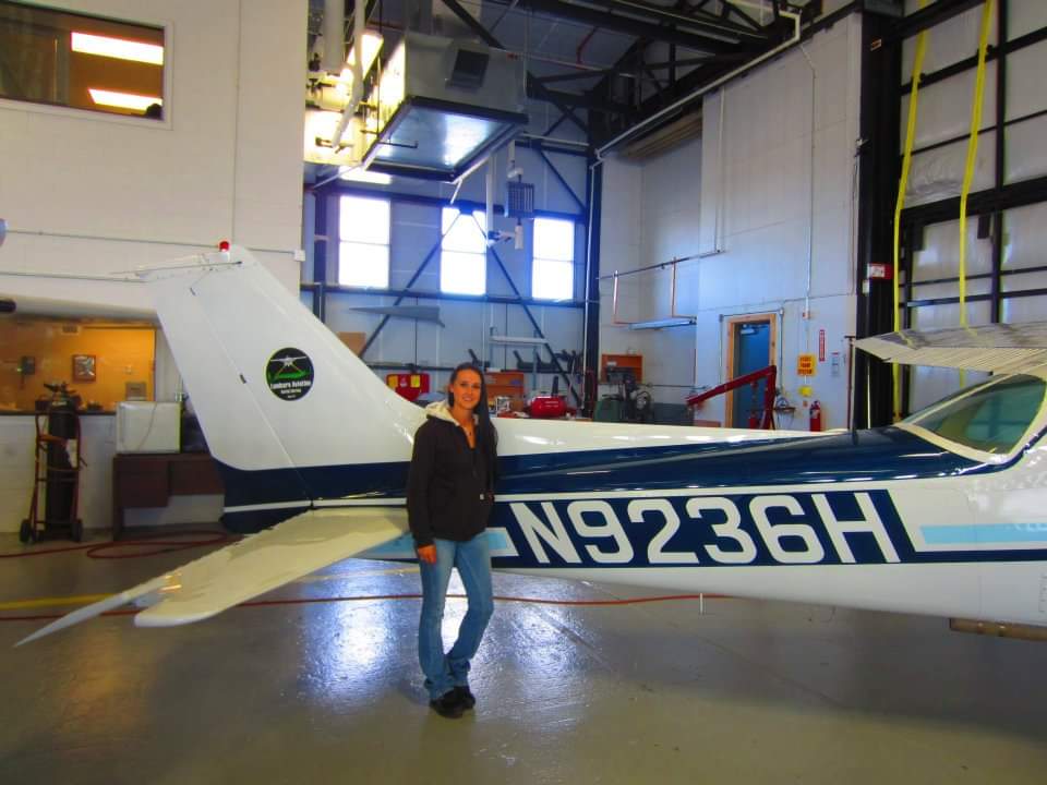 Nikki beside LandCare Aviation's Cessna N9236H in the hangar.