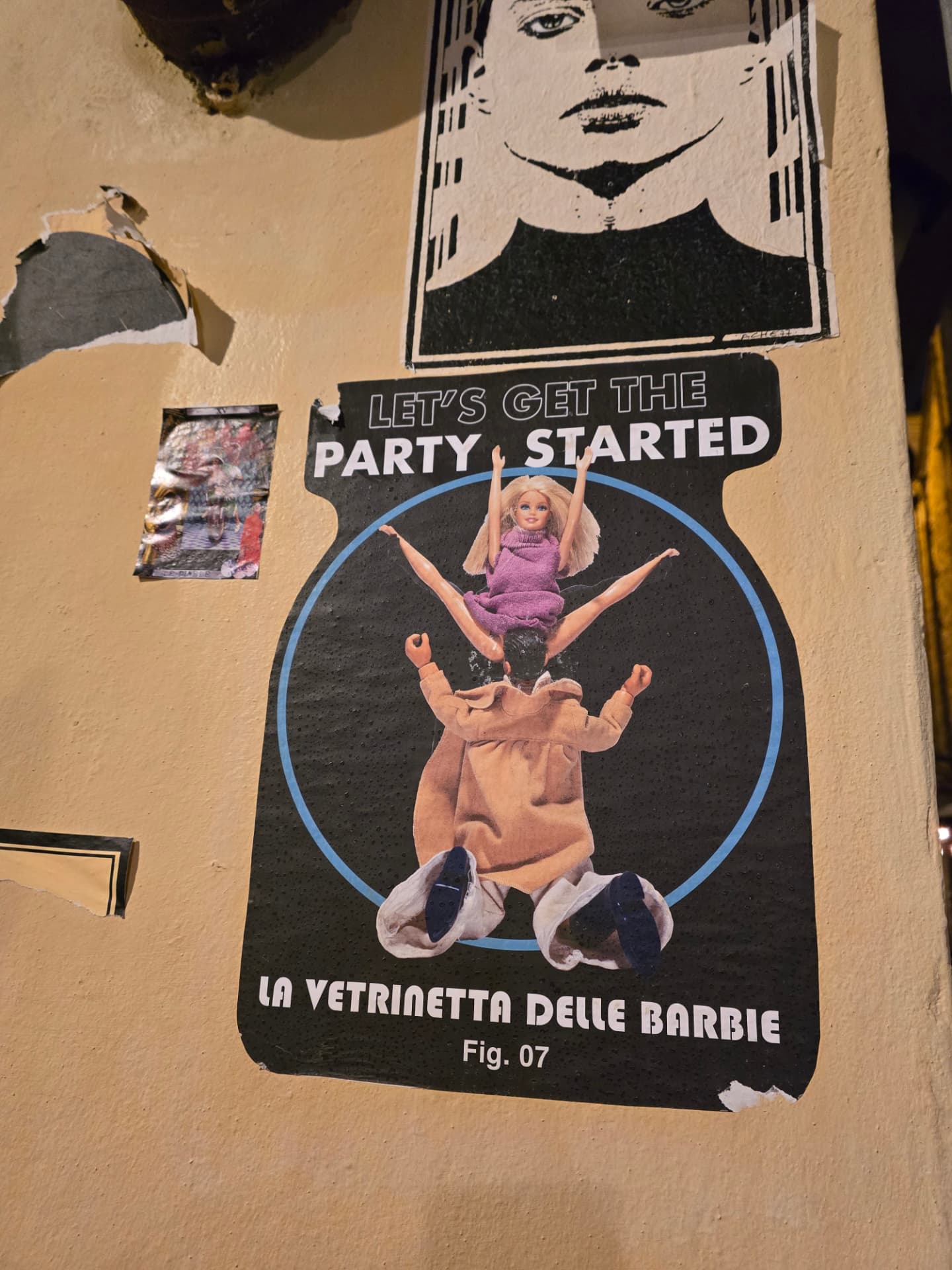 A street poster reading Let’s Get the Party Started, La Vetrinetta delle Barbie, pasted on a worn wall.