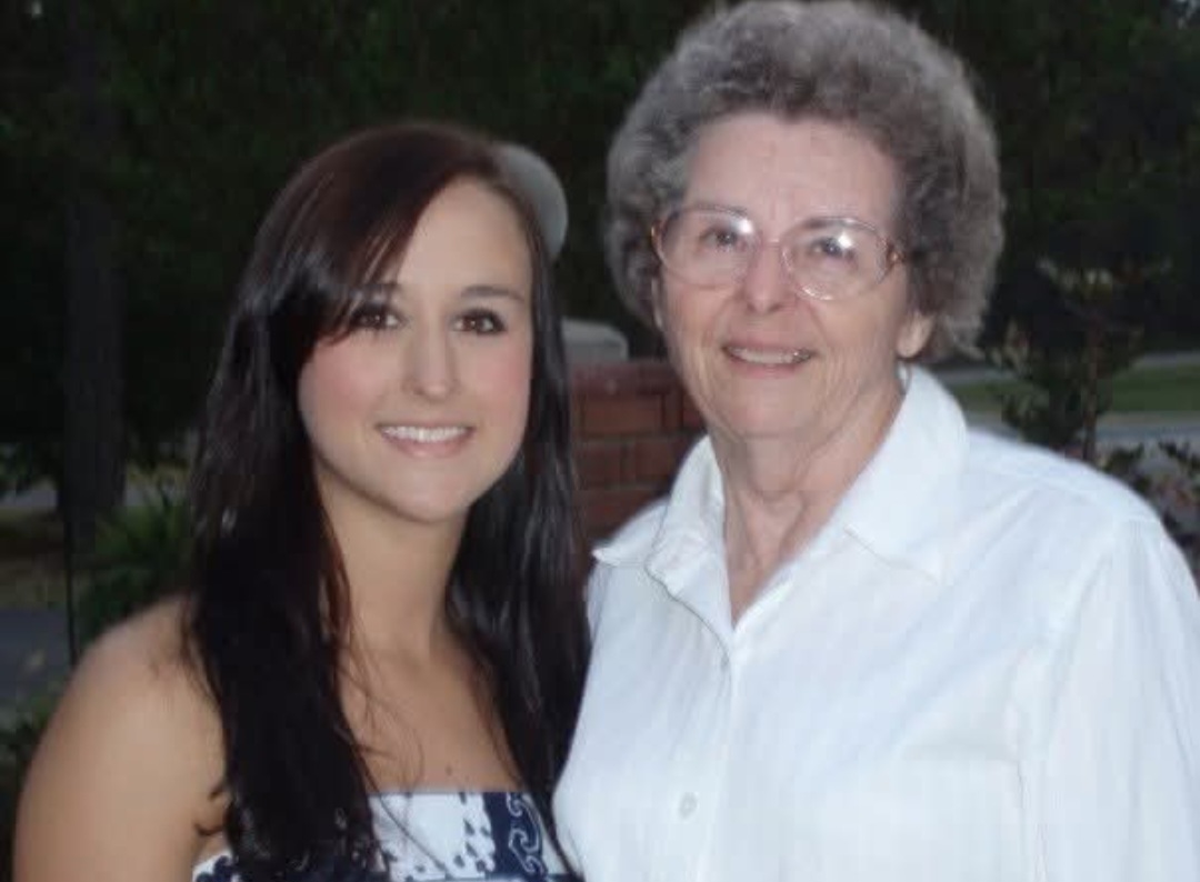 Nikki and Granny Louese standing together outdoors at dusk.
