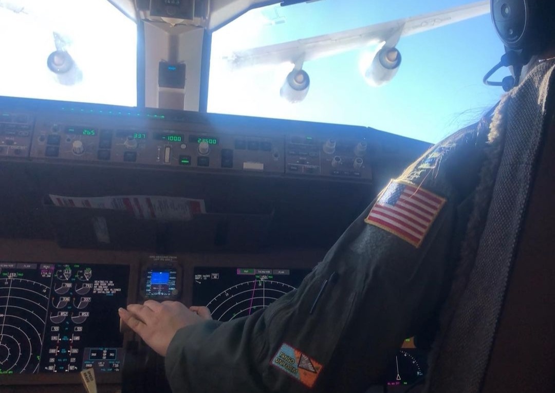 Nikki's hand on the throttles while flying close behind a tanker's engines.