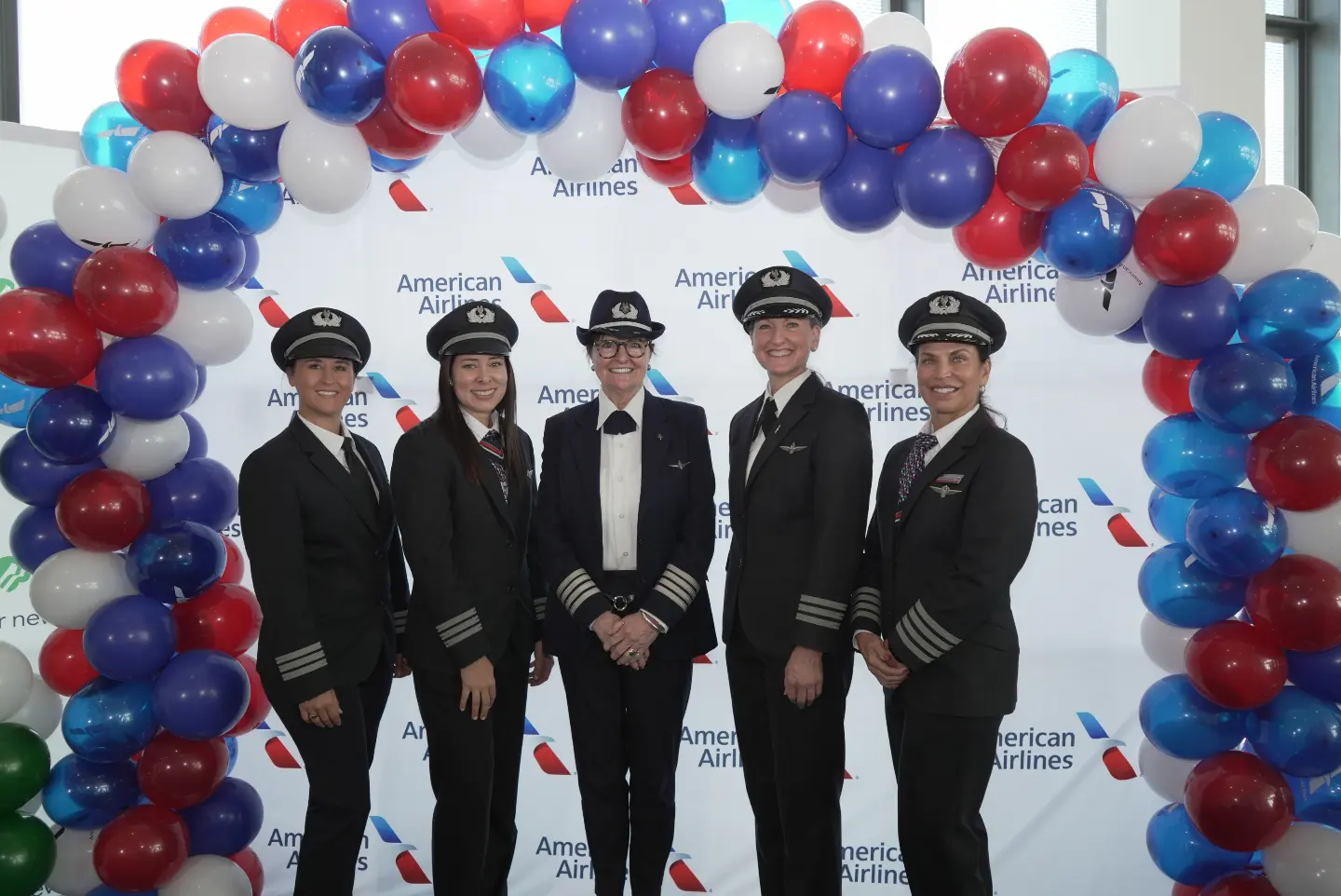 Nikki, Bonnie Tiburzi and fellow American Airlines women pilots under a balloon arch.