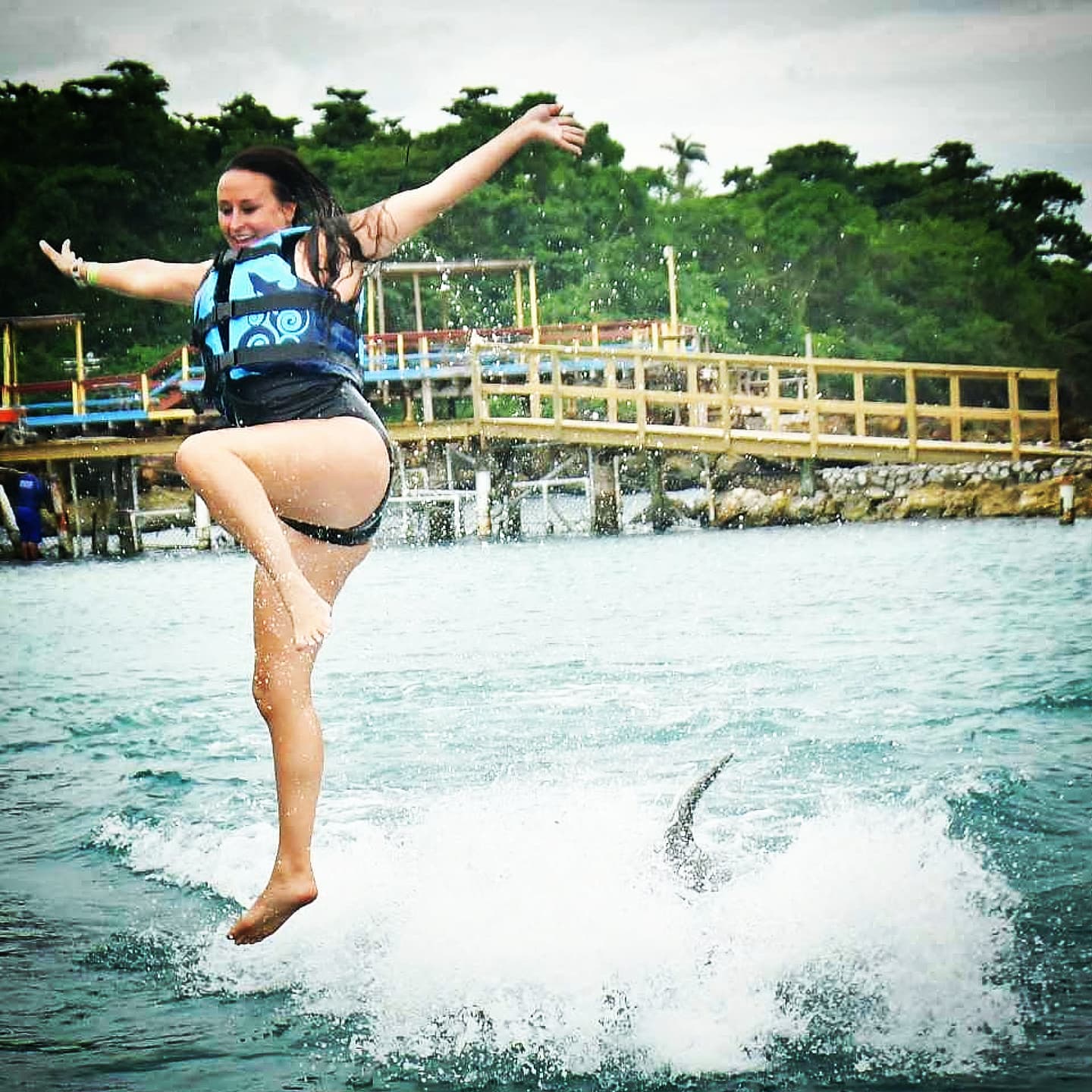Nikki mid-air in the spray, arms flung out.