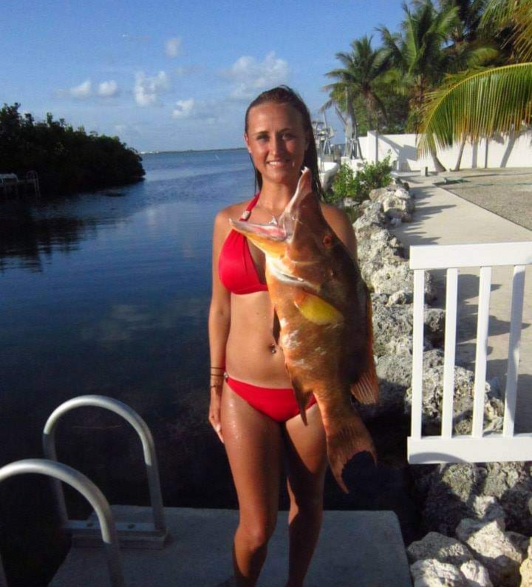 Nikki on a seawall holding a large hogfish.