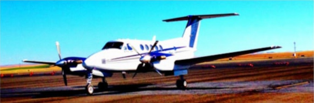 A King Air on the ramp against a clear blue sky.