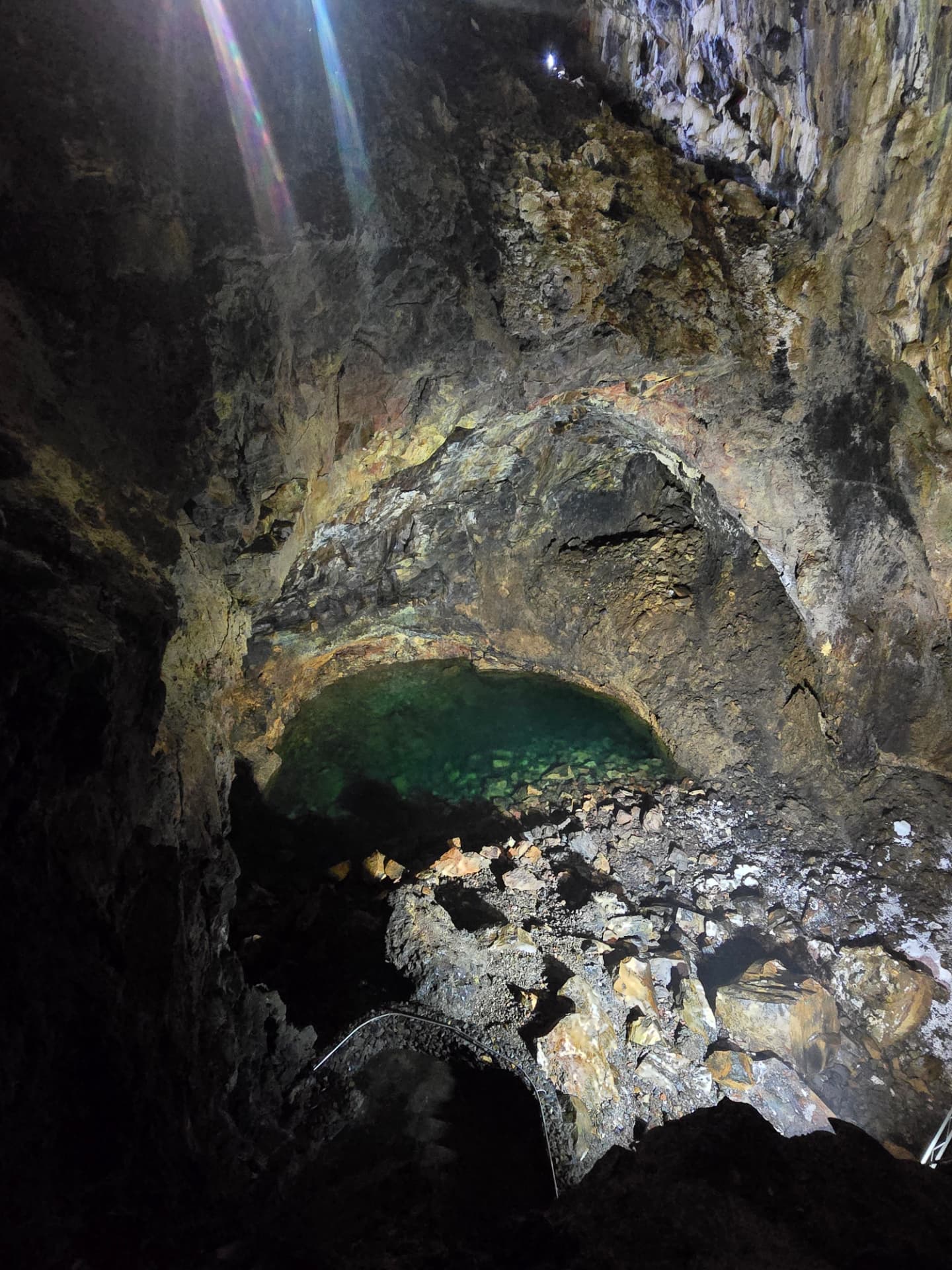 A clear green pool at the bottom of a volcanic cave, Terceira.
