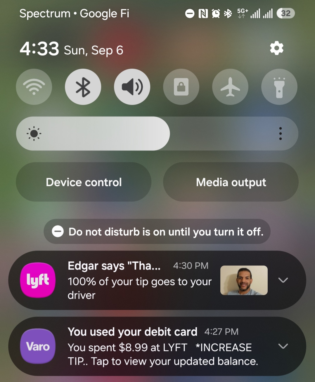 A phone notification shade showing a Lyft message that reads: Edgar says "Tha..." — 100% of your tip goes to your driver, with the driver's photo beside it.