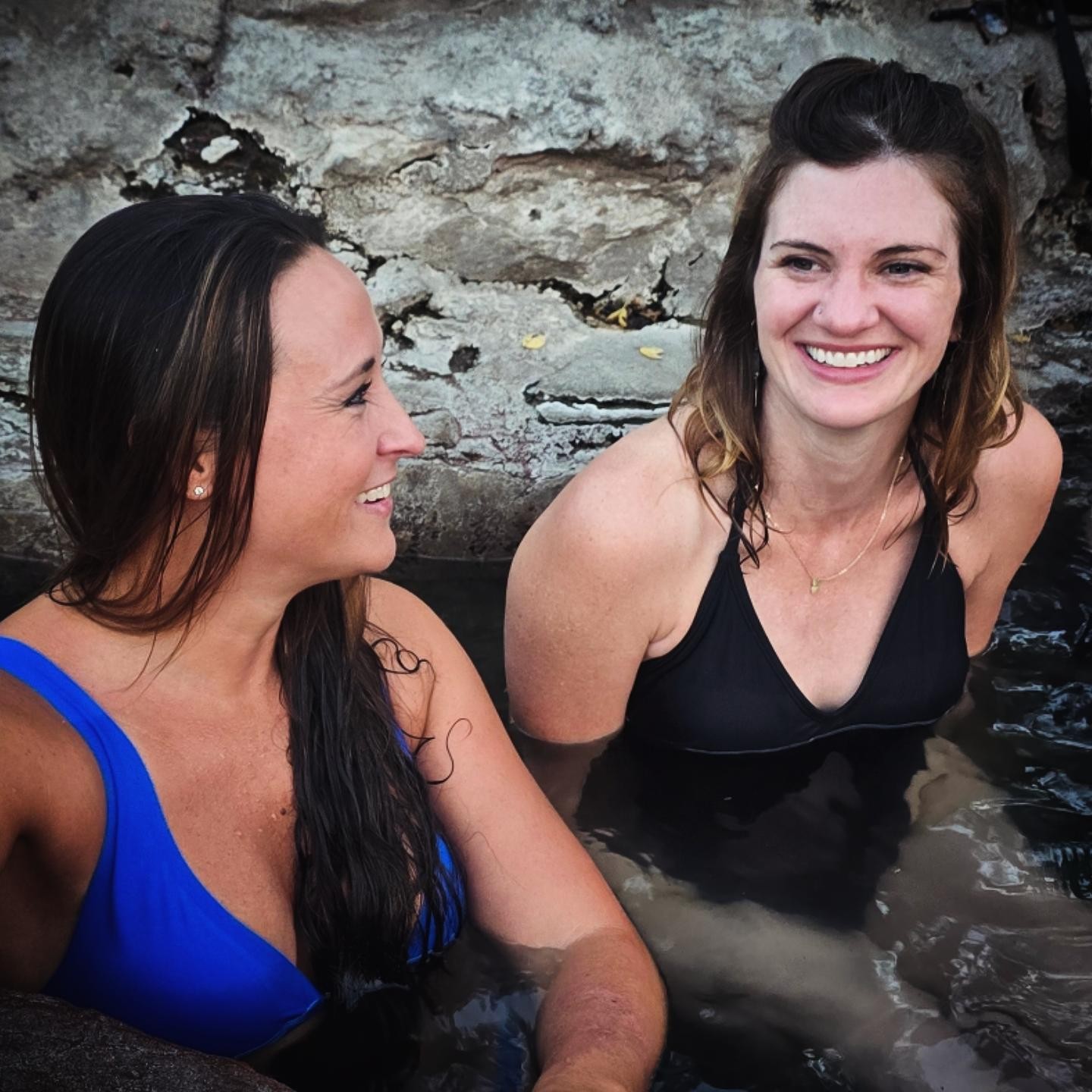 Nikki and Ali smiling side by side in the hot spring.