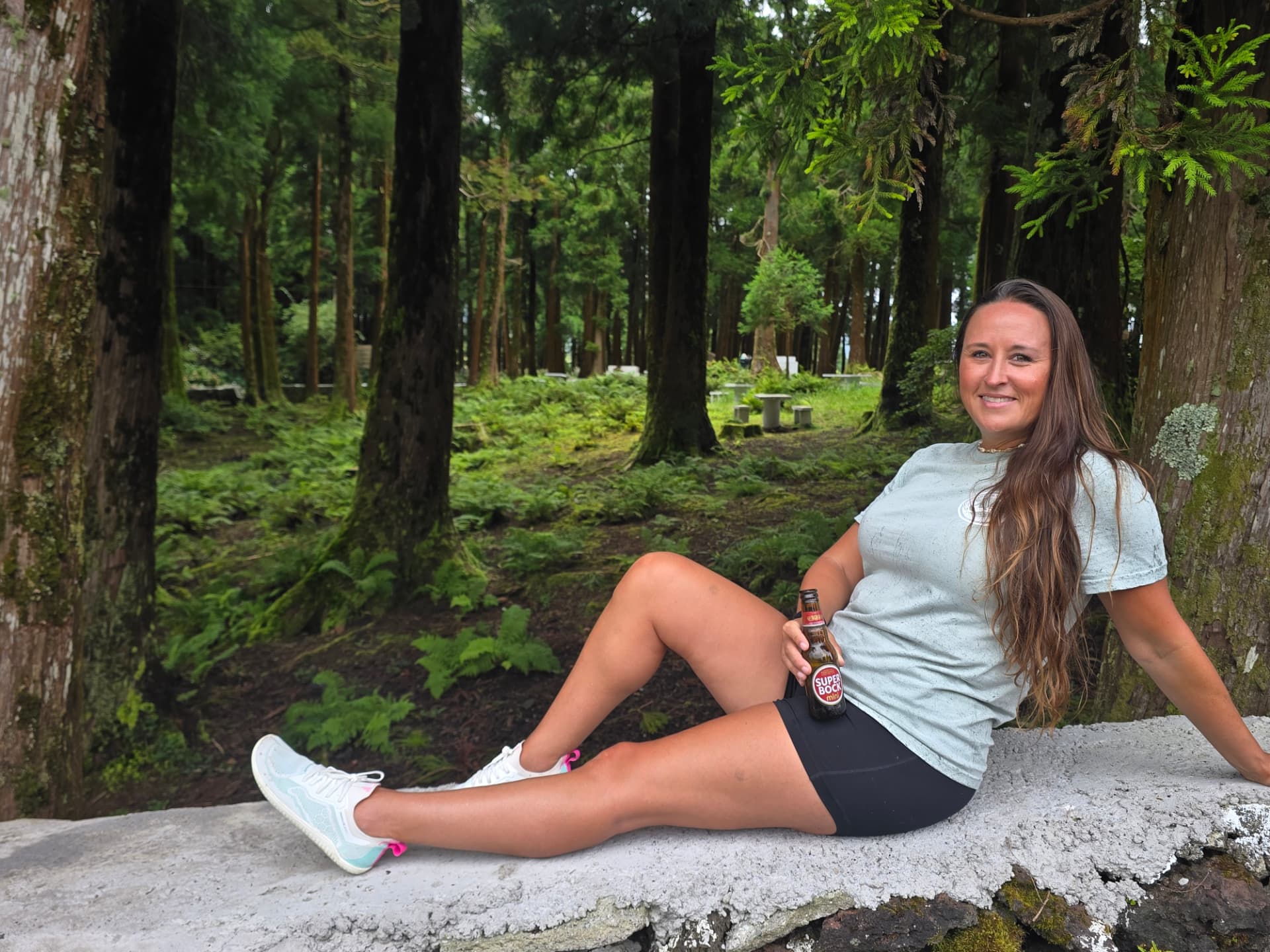 Nikki sitting in the fern-filled woods, relaxed.