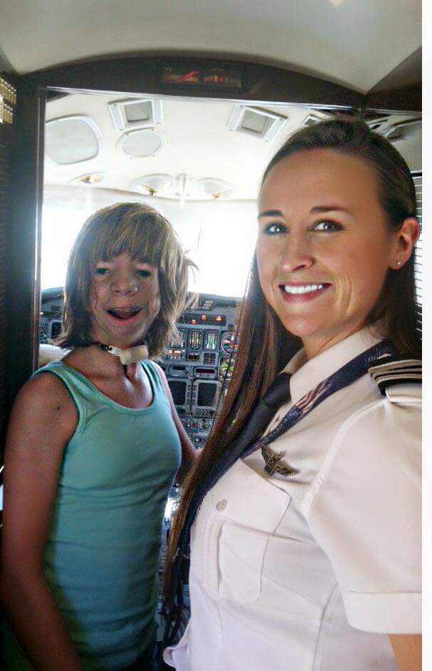 Nikki with a delighted girl at the cockpit door of a jet.