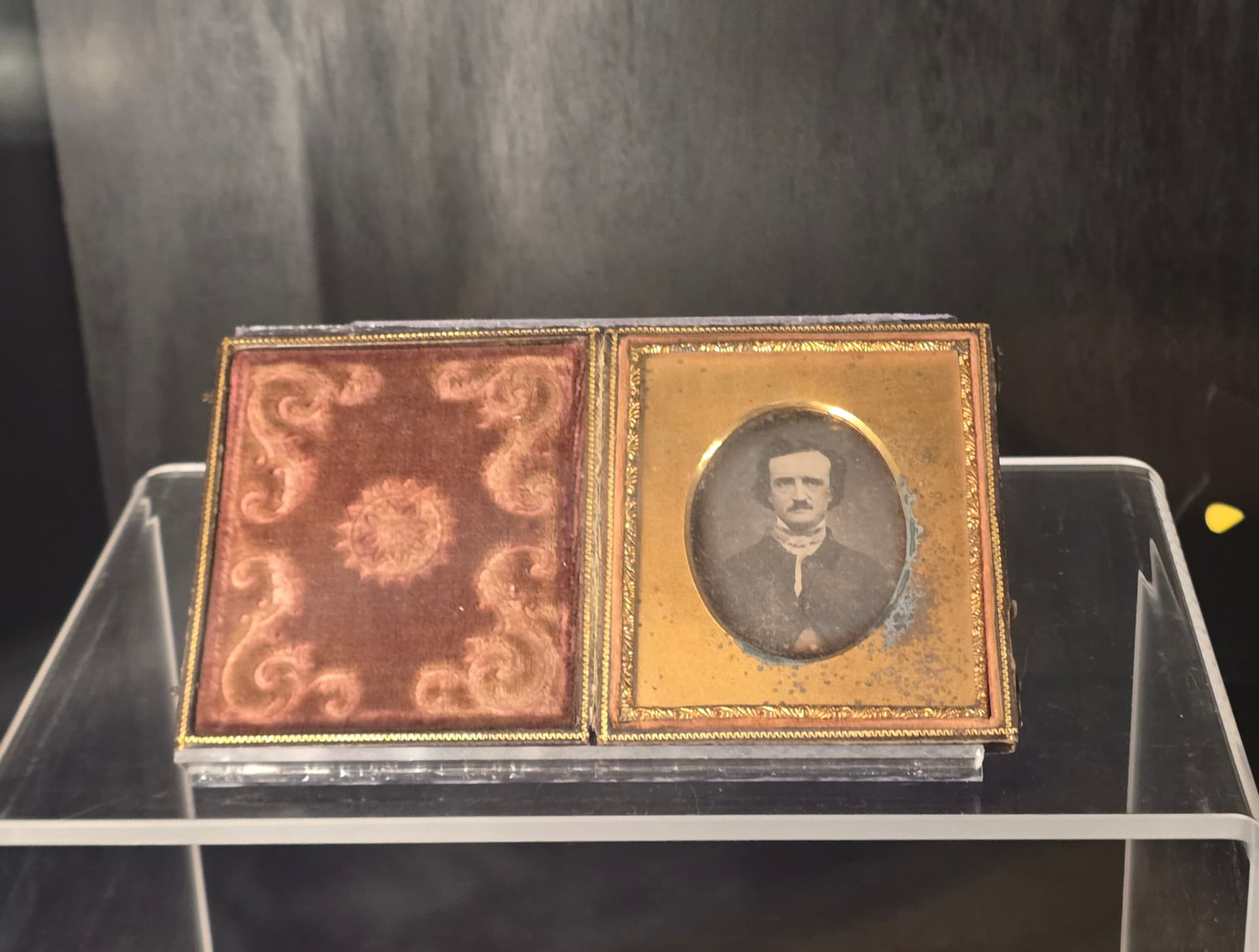 A cased daguerreotype of Edgar Allan Poe, the portrait set in gilt beside a red velvet lining.