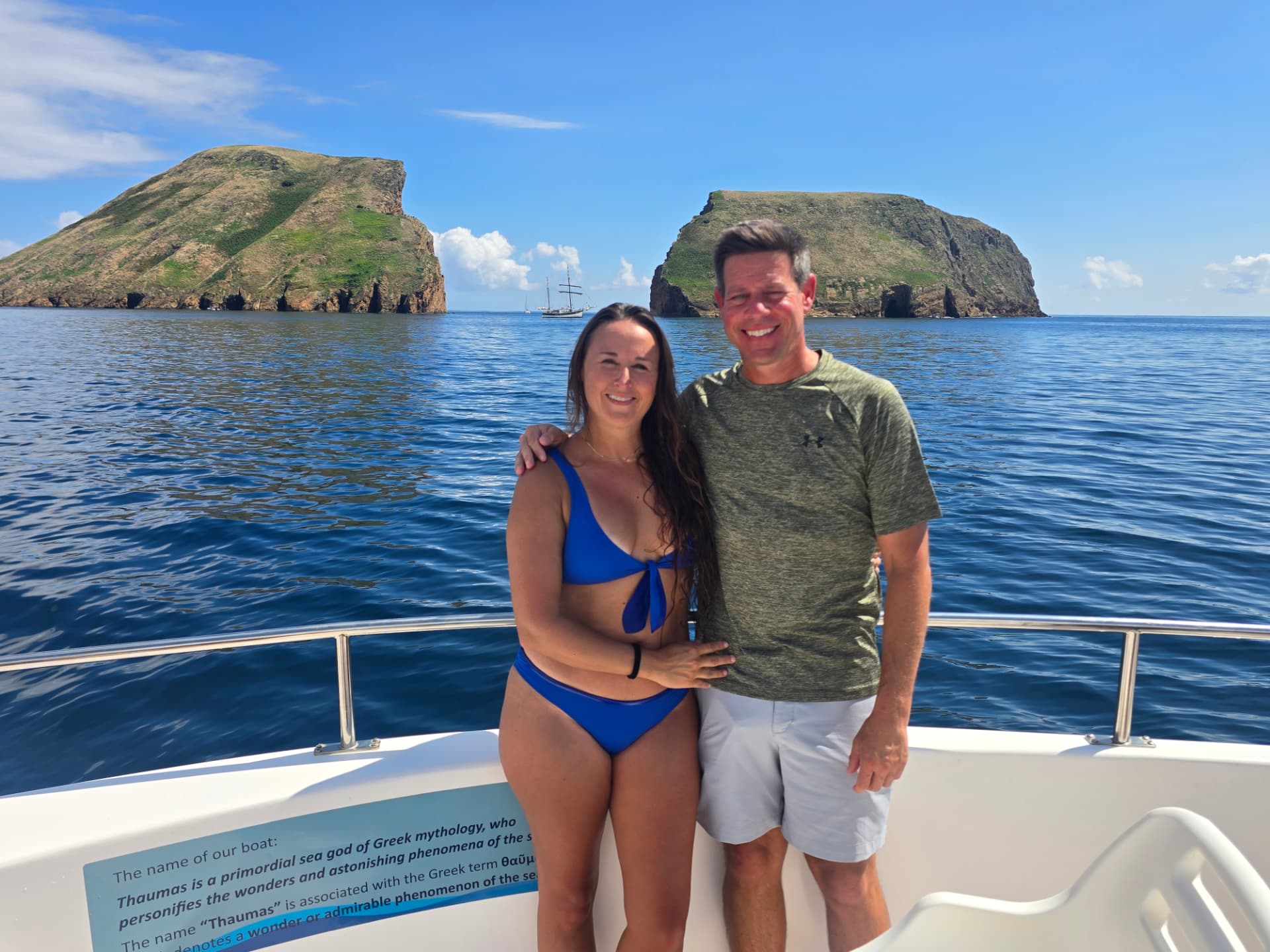 Nikki and Q on the boat with the Goat Islets behind them.