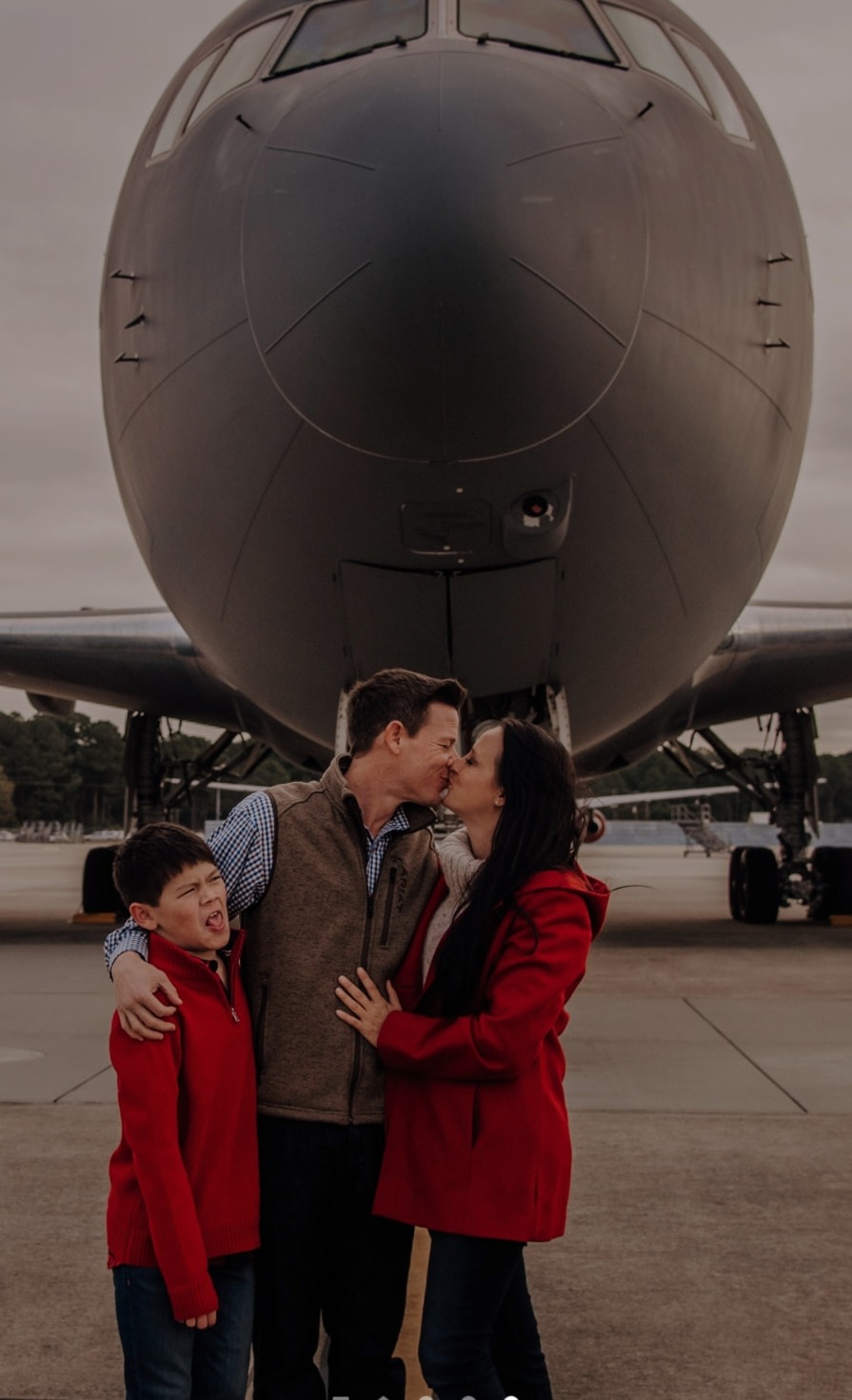 A kiss in front of the KC-46 nose while the boy makes a face.