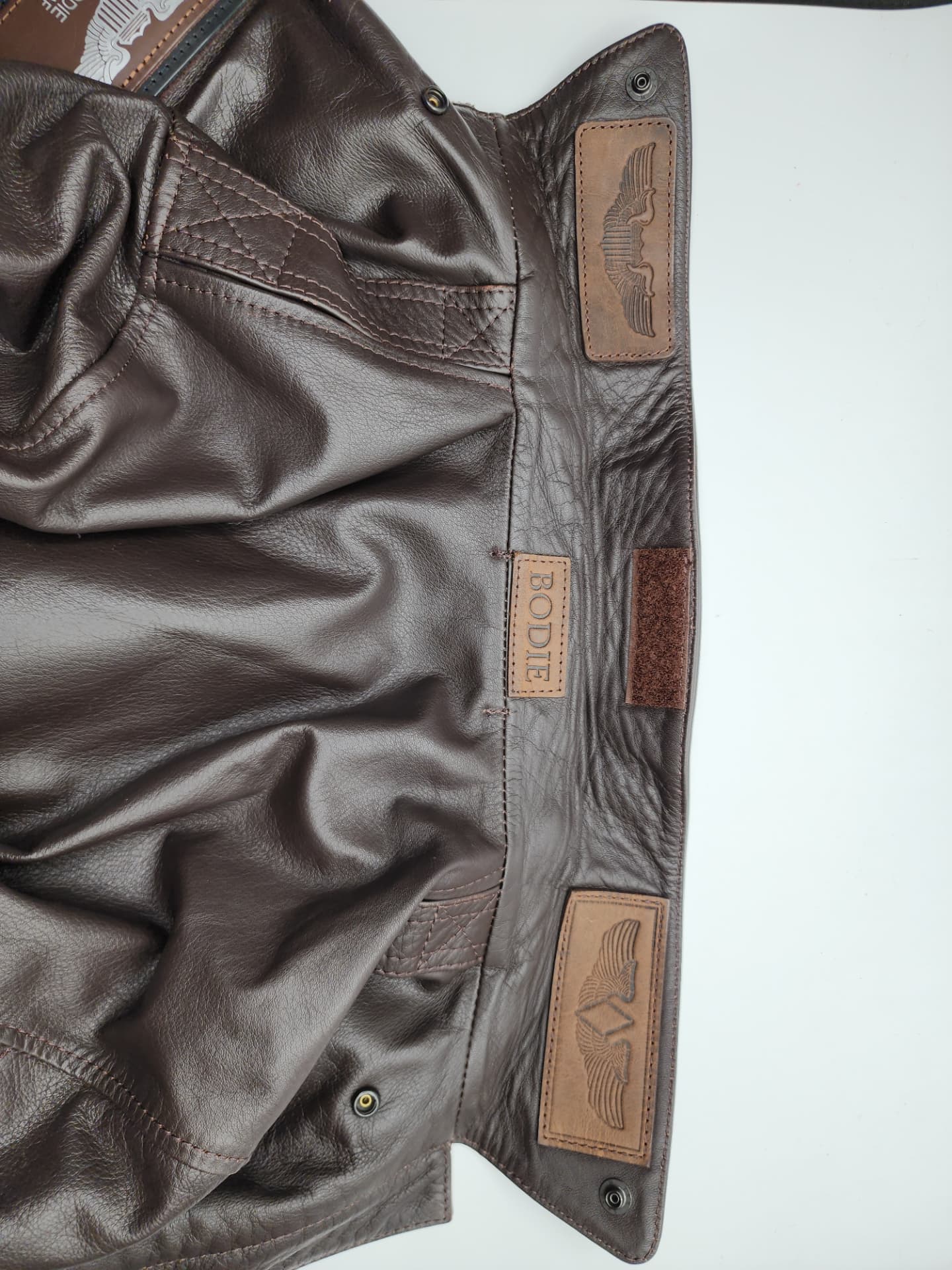 The BODIE name patch and embossed wings inside the jacket's leather flap.