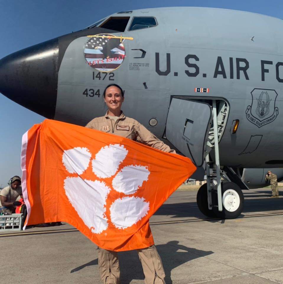 Nikki holding a Clemson Tigers flag in front of the KC-135 "Let's Roll."