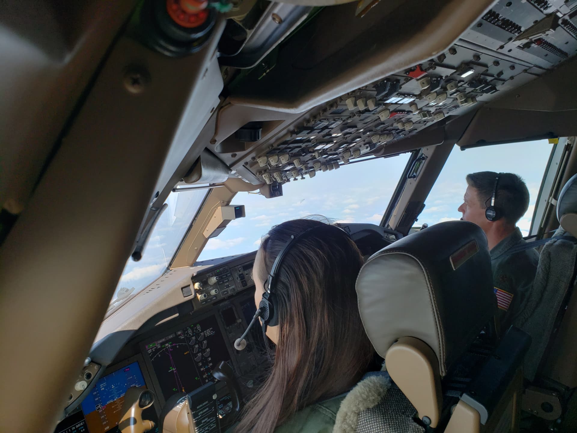 Nikki flying from the left seat of a KC-46, a fellow pilot beside her.