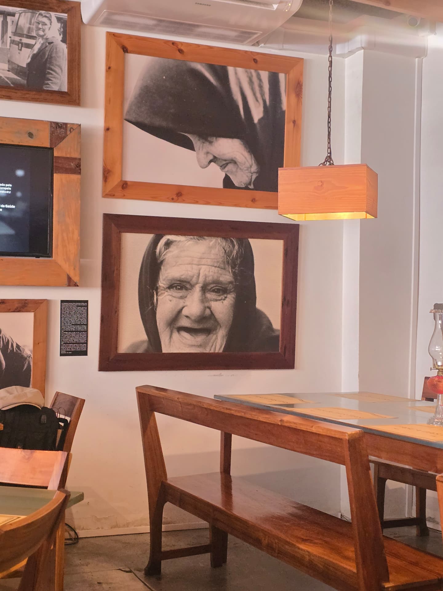 Large black-and-white portraits of cloaked women on the walls at Tasca das Tias.